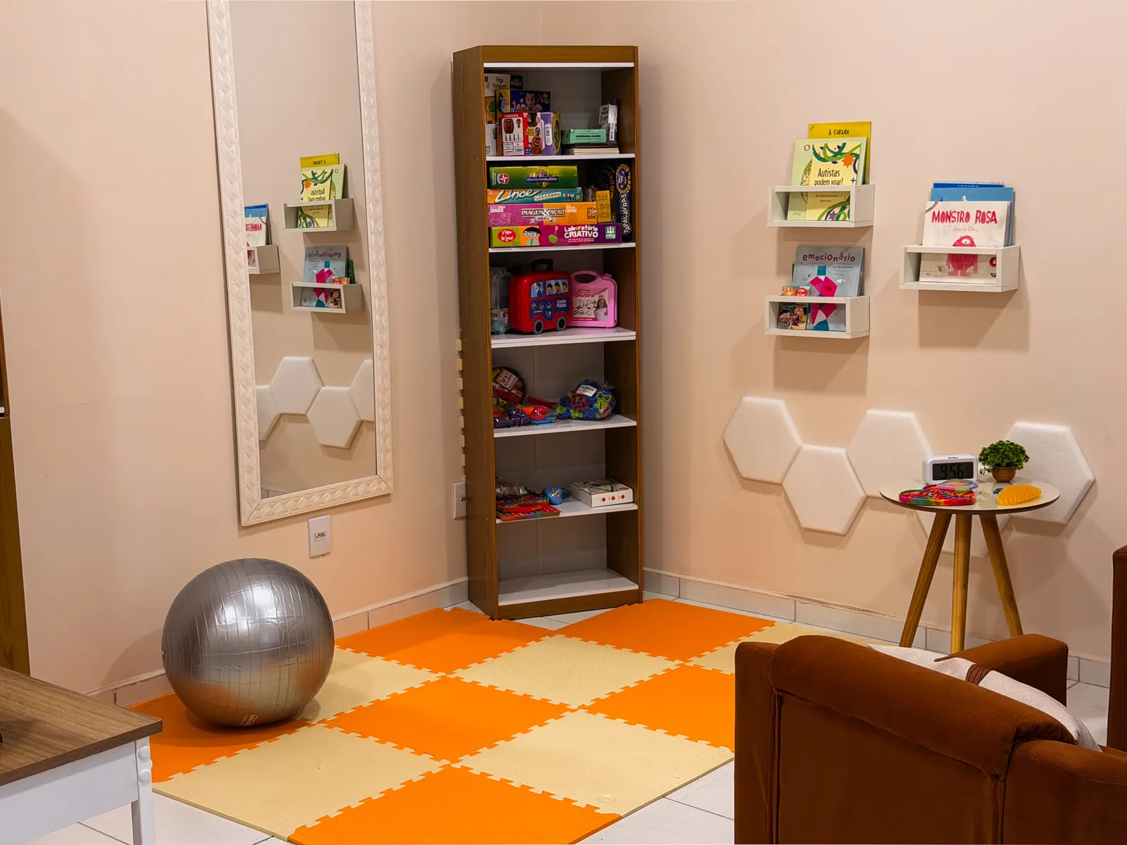 Sala de atendimento com tapete, brinquedos e livros infantis